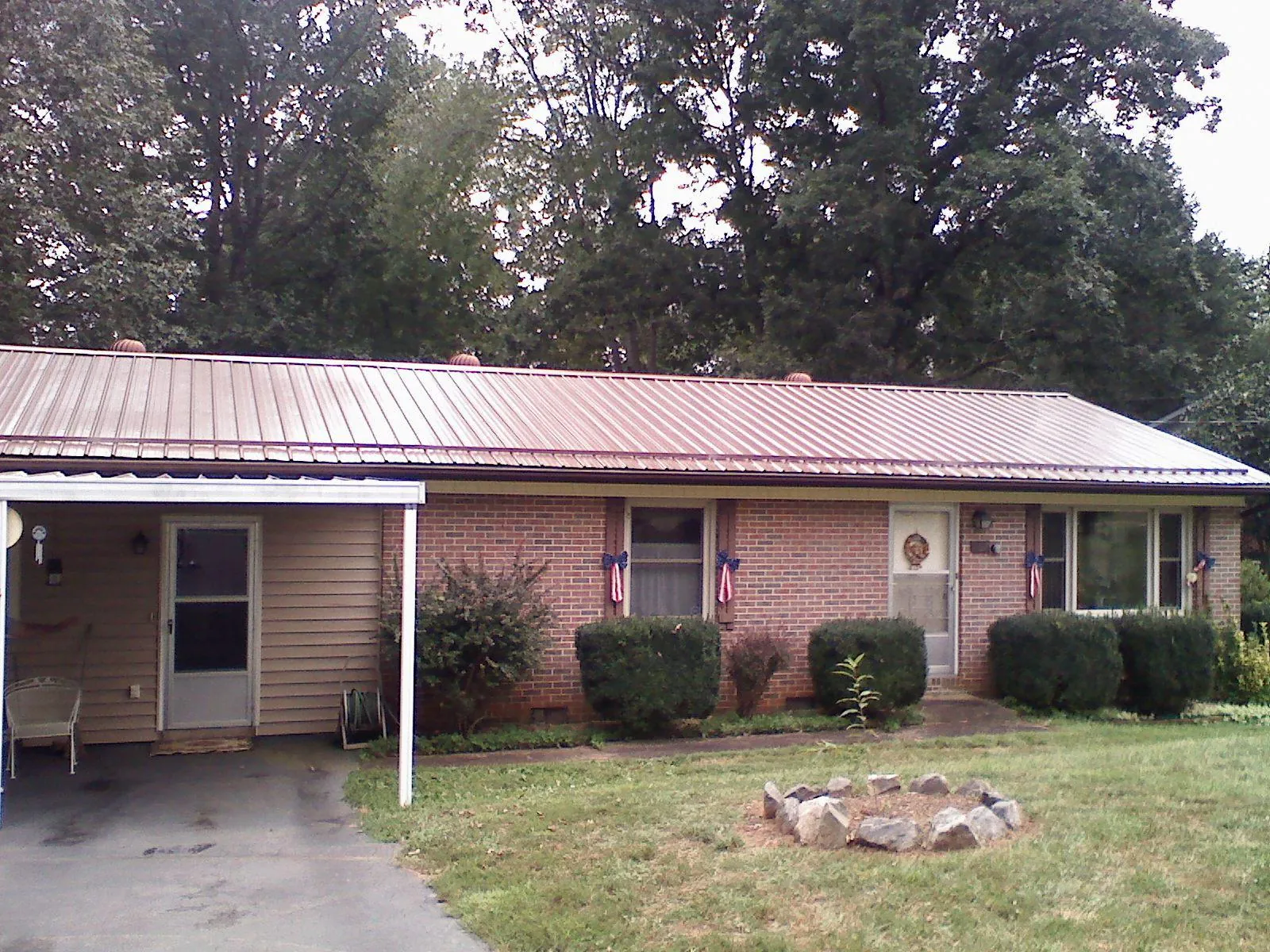 Bronze metal roof and carport on a brick ranch home — Roof Repair work by our crew in Upland